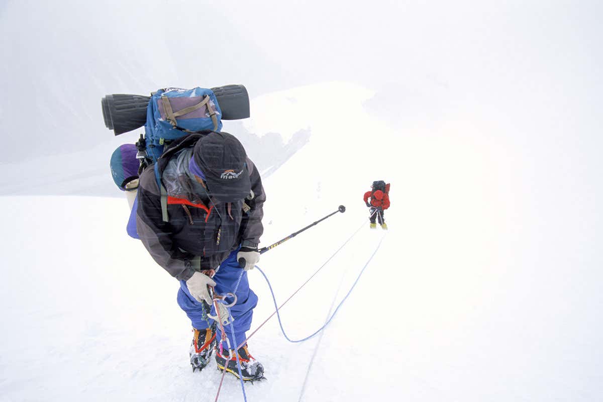 Mountain-climbers in snowy , foggy landscape