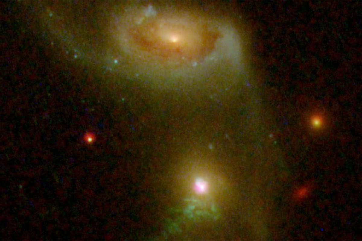 The two distant galaxies appear to be connected by a bridge of stars, suggesting that they previously collided, a long-suspected trigger for AGN activity