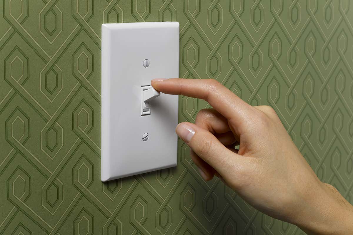 A hand hovering on a lightswitch