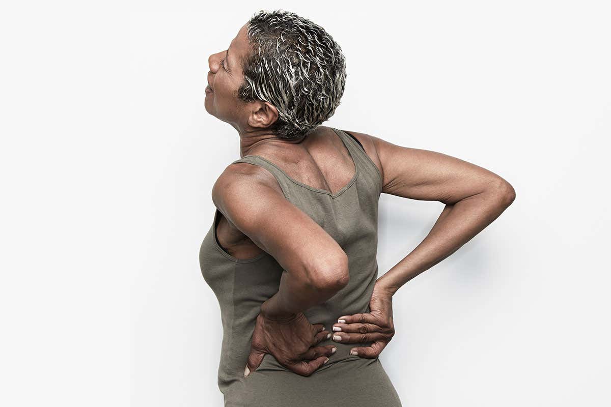 A woman holding her lower back in pain
