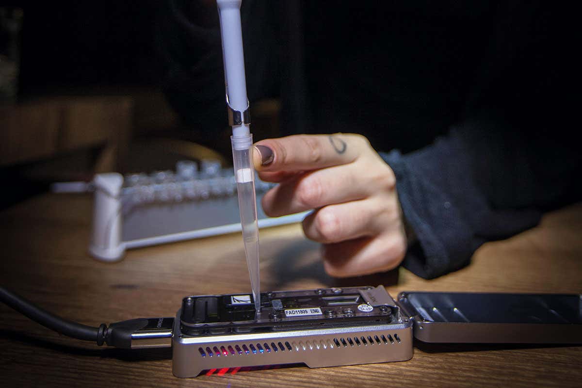 Technician injects fluid into MinION DNA sequencer