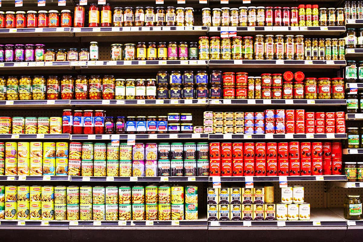 A supermarket shelf stocked with different cans and jars