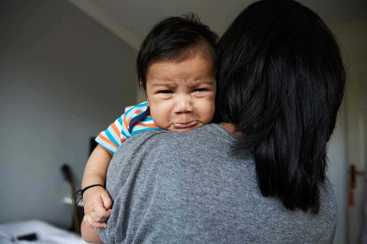 A crying baby being comforted