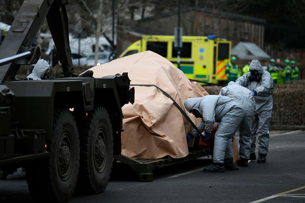 Military personnel in protective clothing removes vehicles from a car park in Salisbury, Britain, 11 March 2017