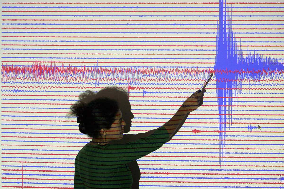 A researcher pointing at seismograph readings recorded from a massive quake near Sumatra's in 2005.