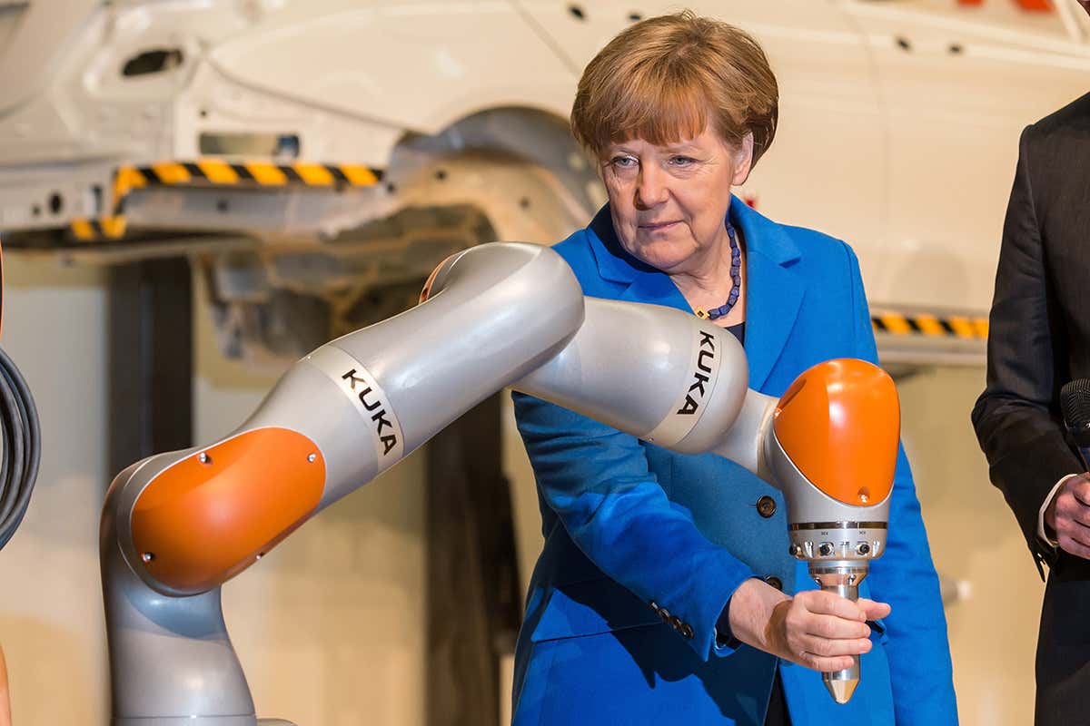 Angela Merkel touches a robotic arm