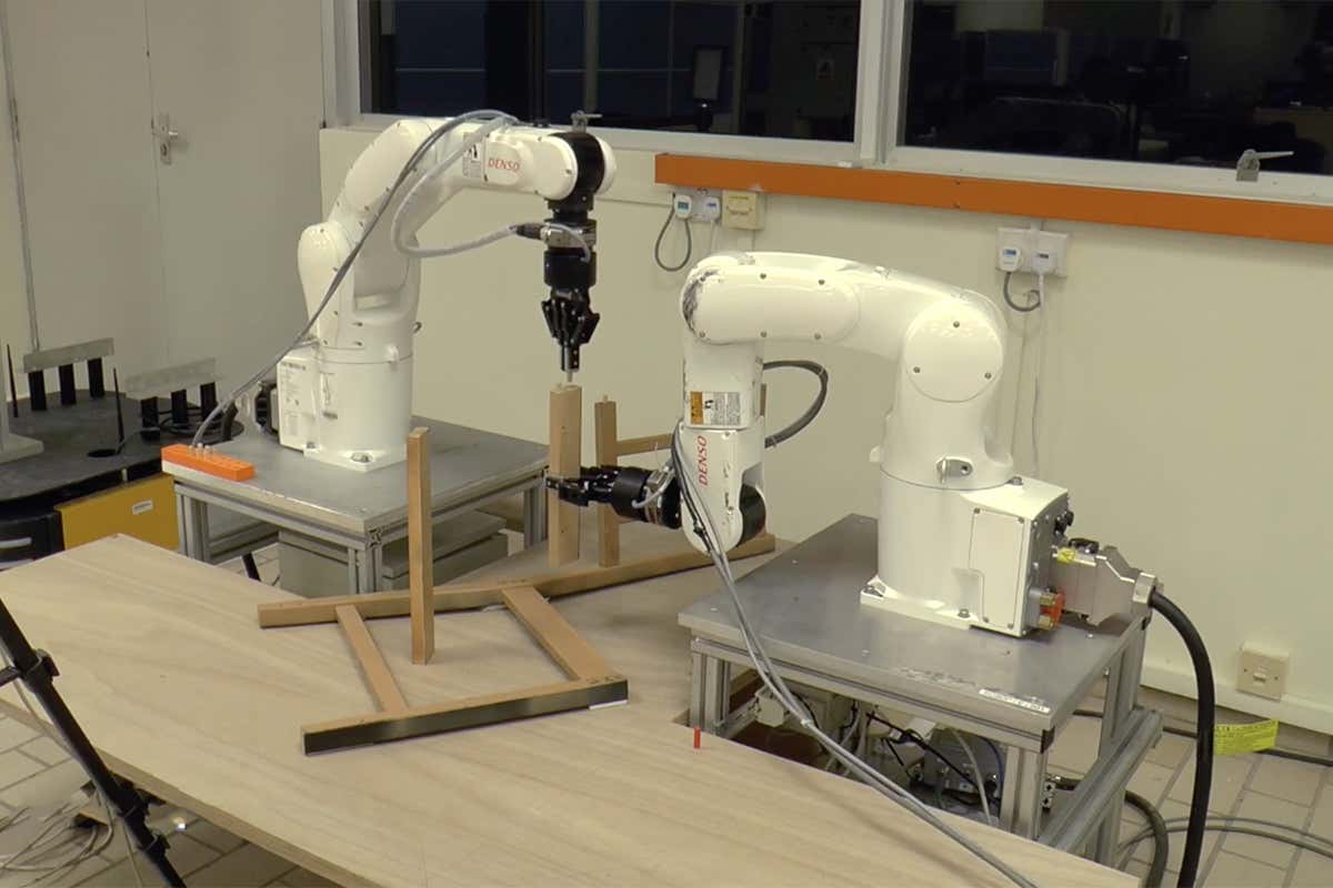 Two robotic arms construct a chair