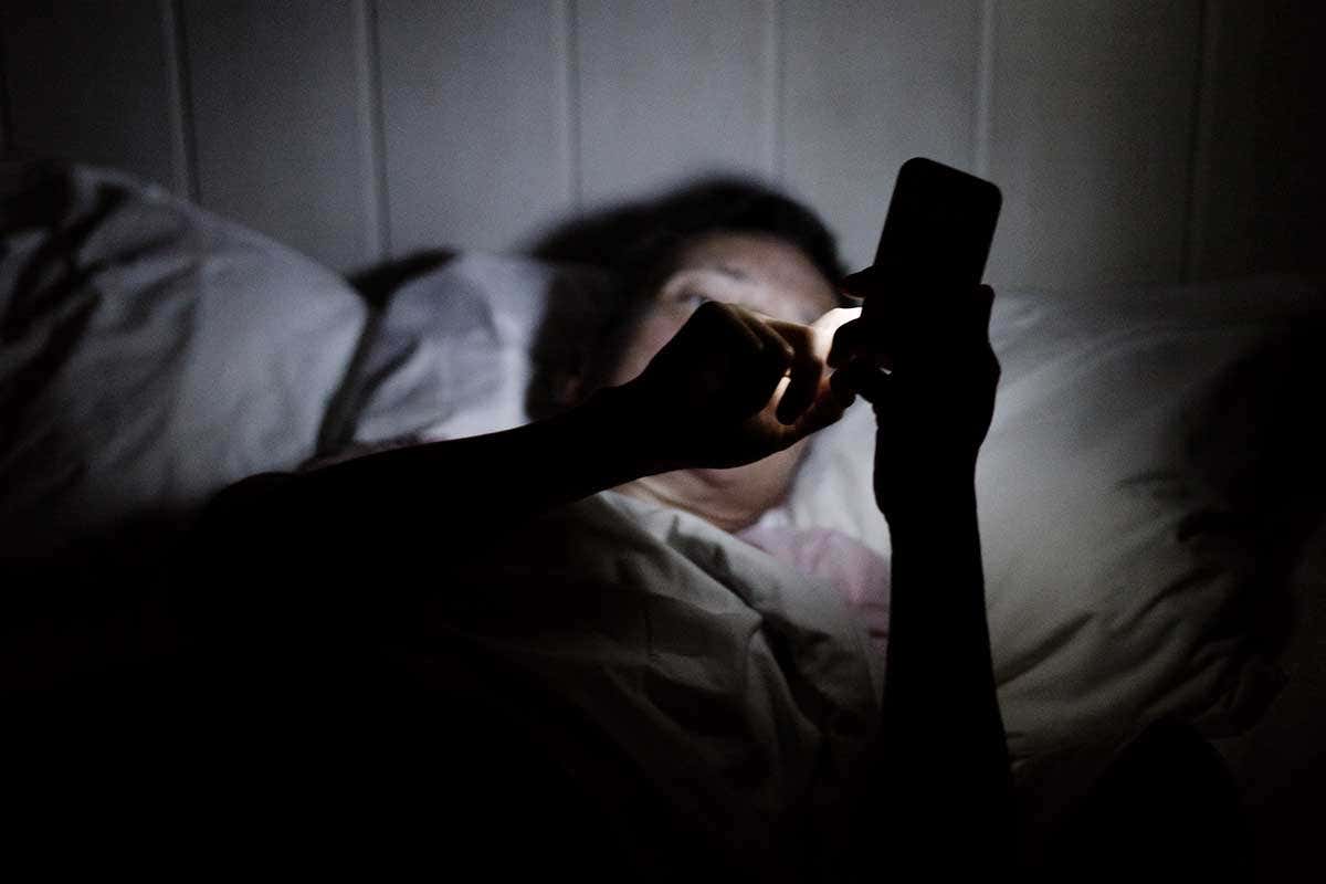 A person in bed with a mobile phone
