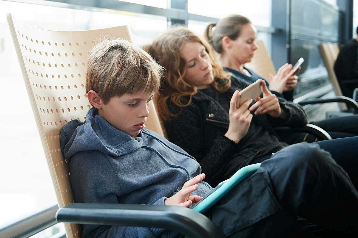 A row of young people sat using their smartphones