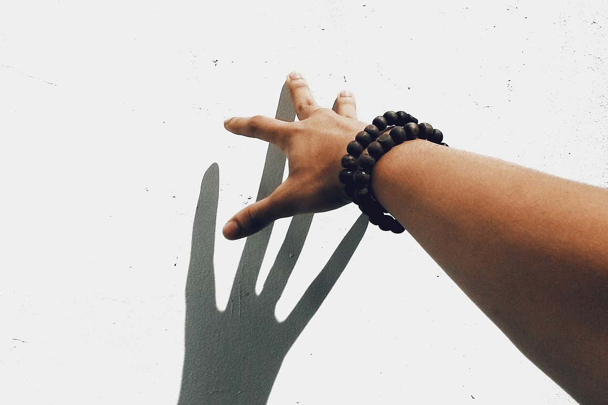 A hand touching a white wall