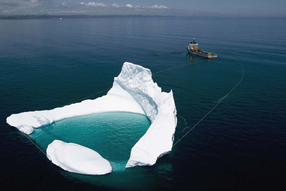 Iceberg being towed away from an oil rig