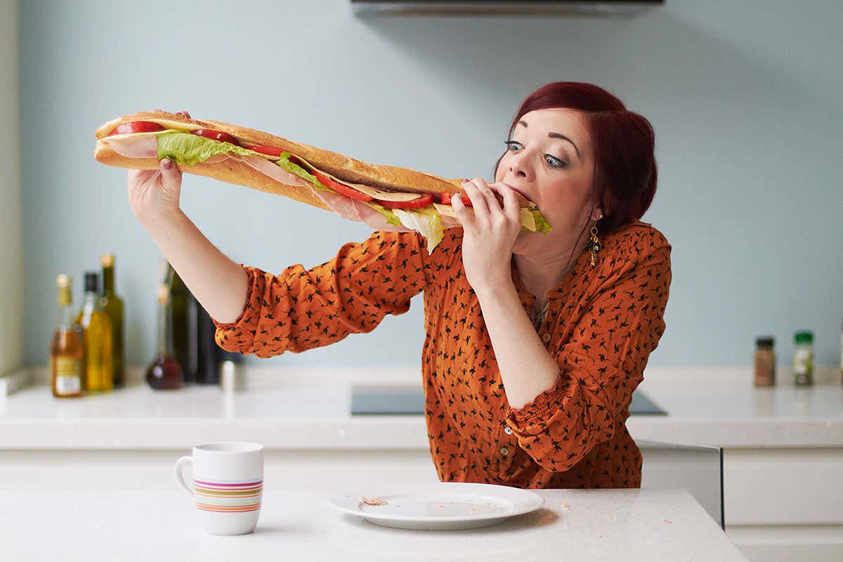 A woman eating a very large sandwich
