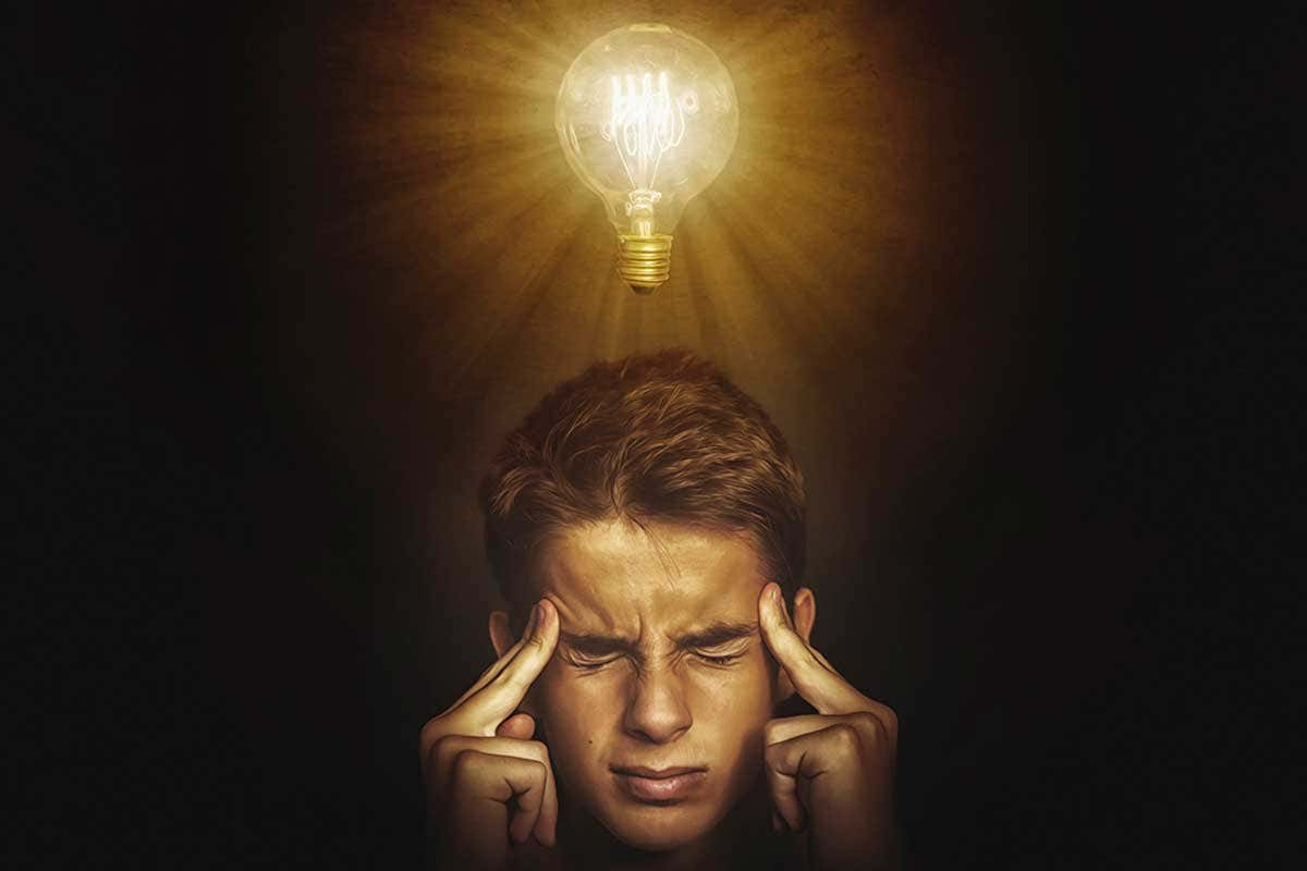 A man thinking hard and a lightbulb