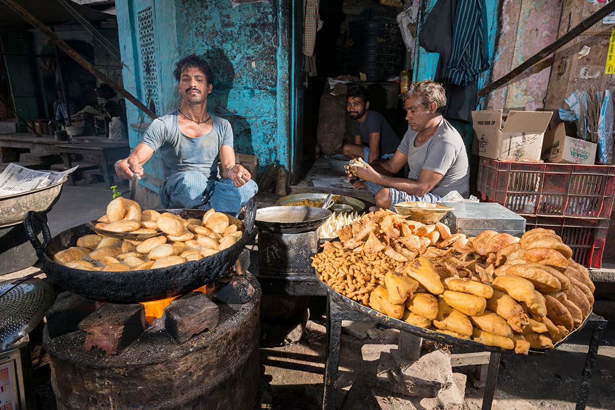 Deep fried snacks like Samosa are prepared in a small street of the old walled Pink City.