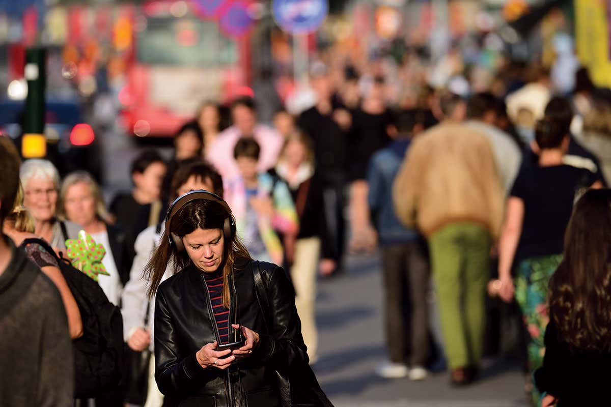 Lady using phone in busy street