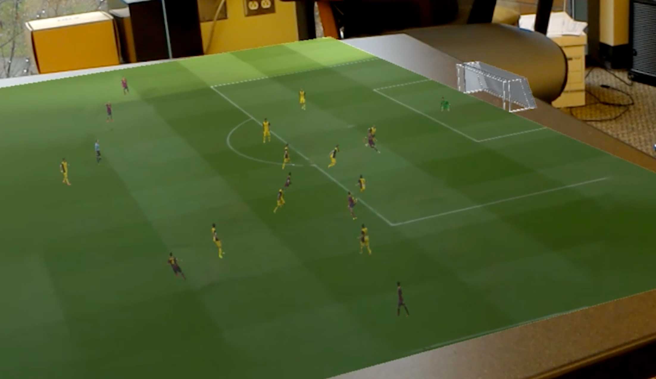 Small virtual football players runaround on a real-life table
