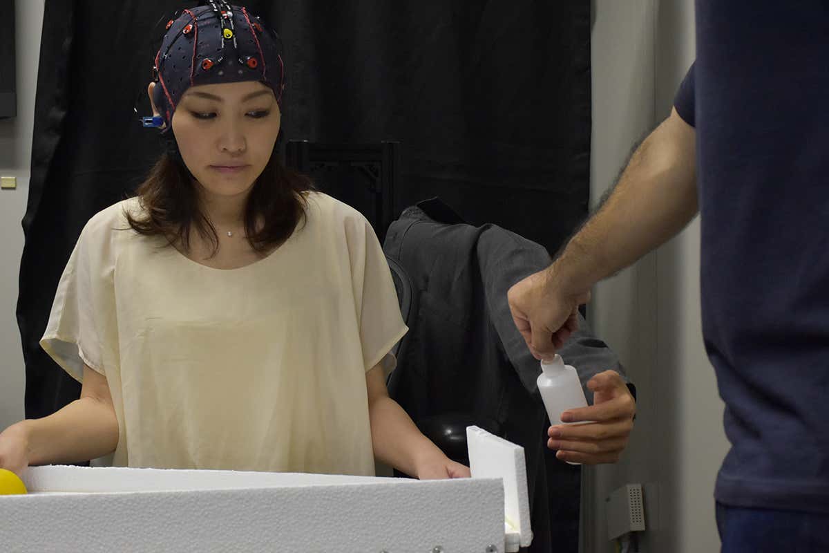 A lady controlling a robot arm with her mind