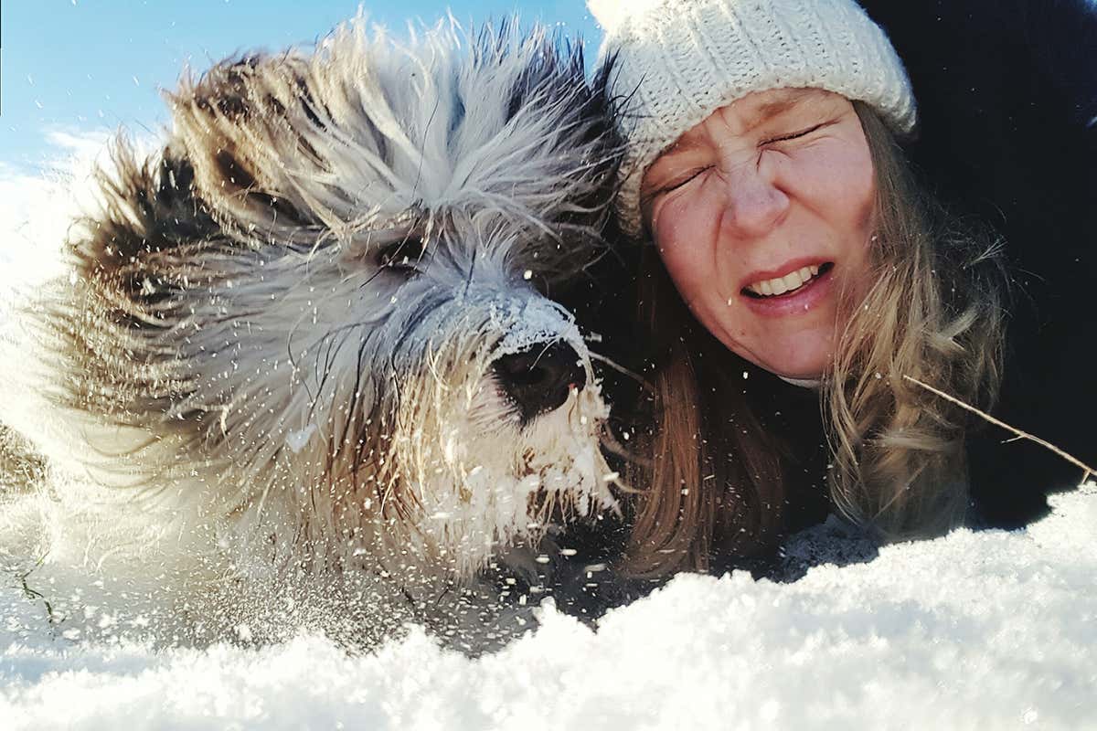 A woman in the snow with a dog