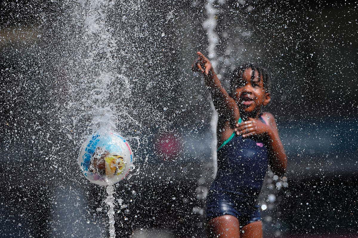 A girl plays in a fountain