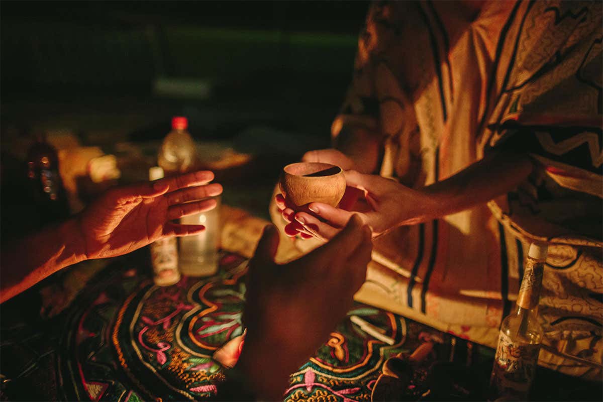 A man being handed ayahuasca