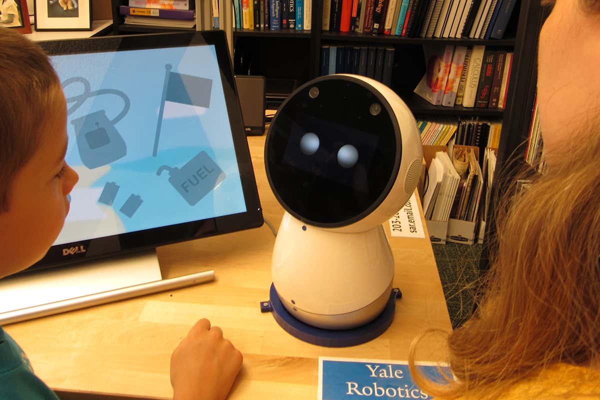 A small robot next to a touchscreen