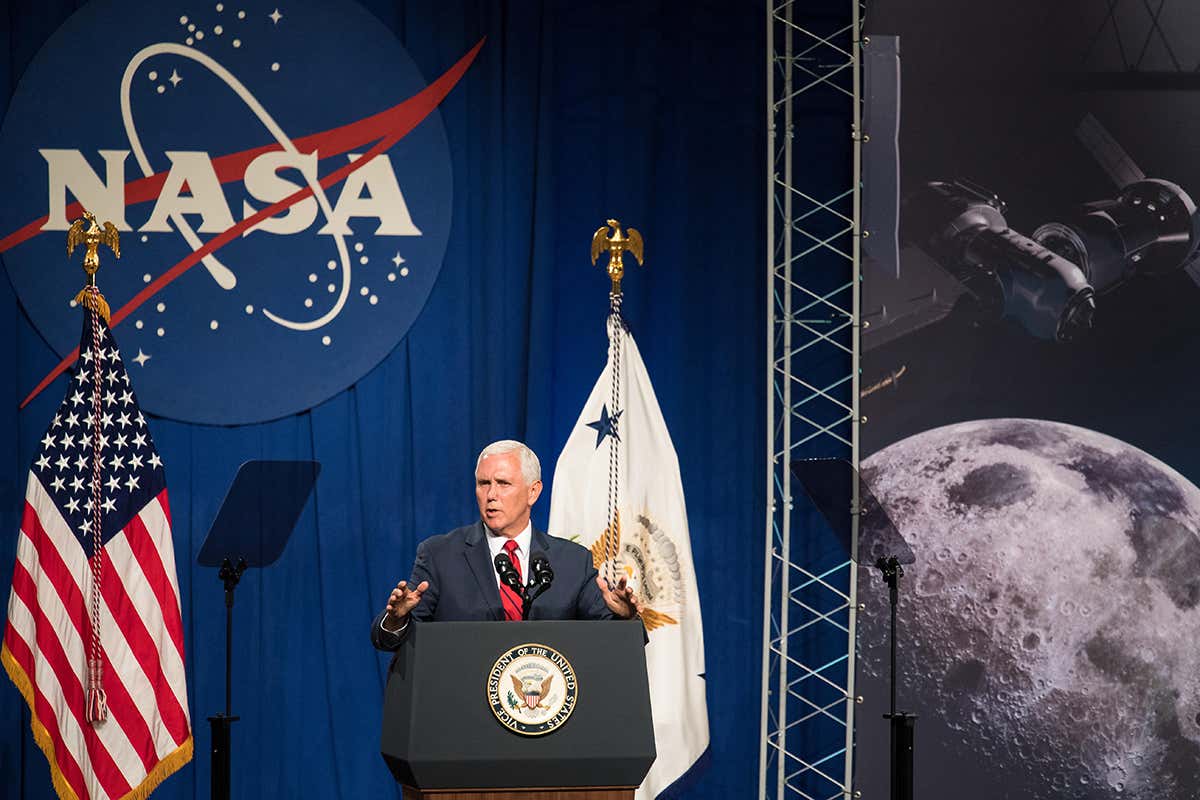 US Vice President making a speech in front of a NASA logo, an American flag and a picture of the moon