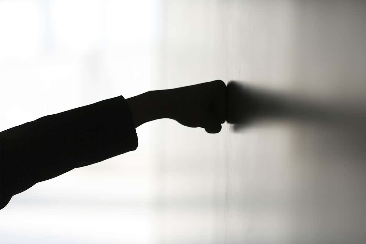 A fist punching a wall