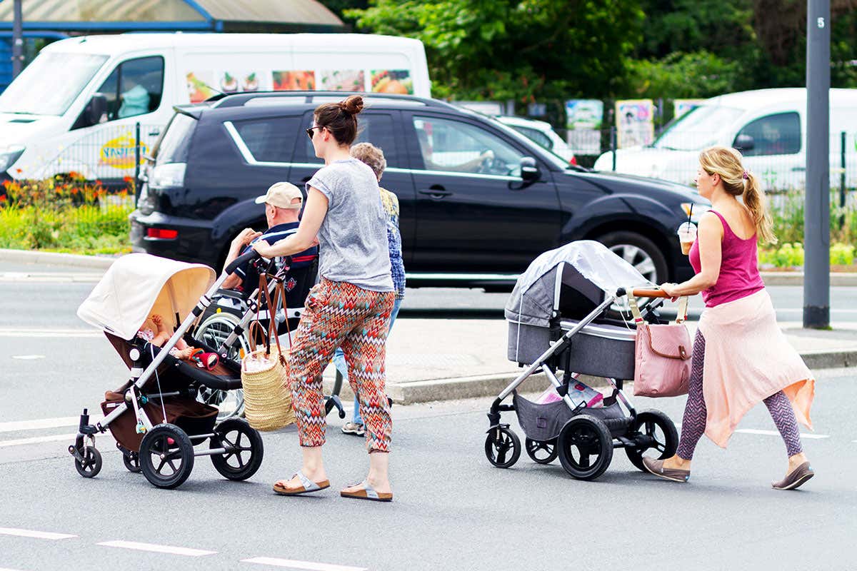 Two people push children in prams