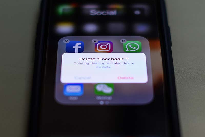 A picture of a smartphone with the Facebook app being deleted