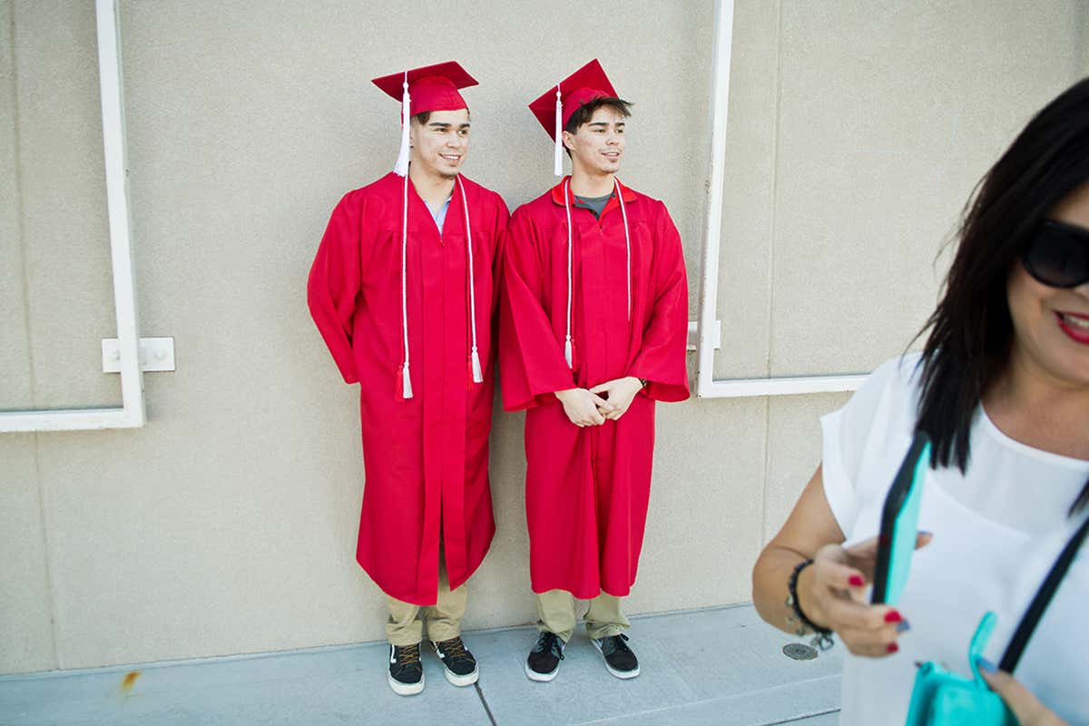 Two people wearing graduation gowns