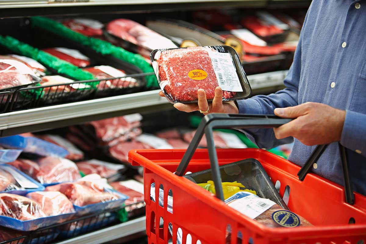 A person considers purchasing meat