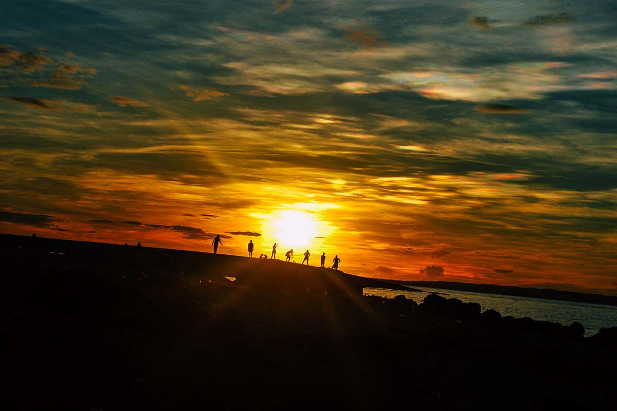 People silhouetted against sky