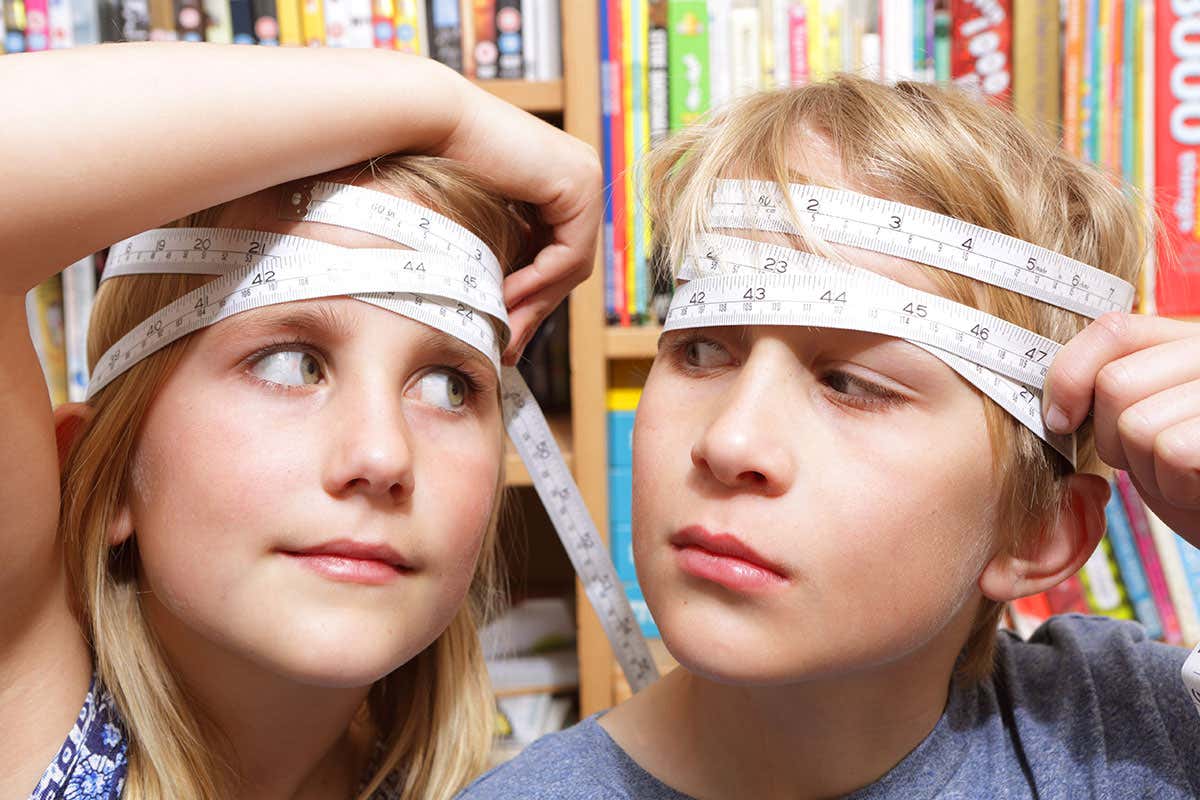 a boy and a girl measuring their heads