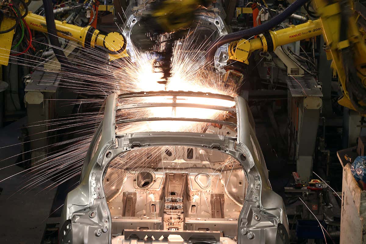 Robotic arms work on a car