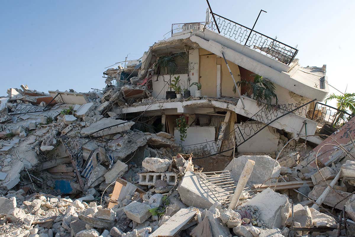 Plants still stand on the balcony of a destroyed building in downtown Port-au-Prince where widespread looting is taking place on January 18, 2010, six days after an earthquake measuring 7.0 on the open-ended Richter scale hit the Haitian capital.