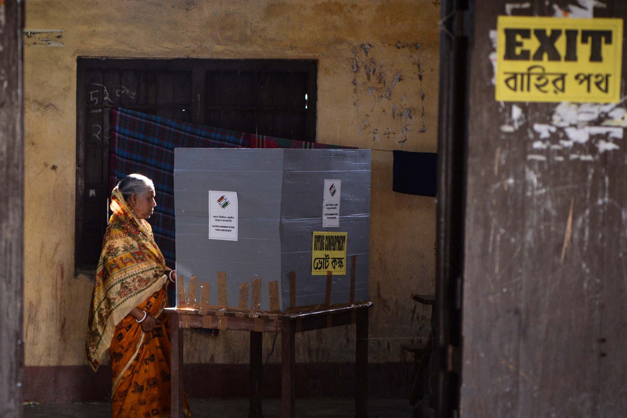 A woman votes in a booth at a polling station during India's general election in Cooch Behar, West Bengal on April 11, 2019