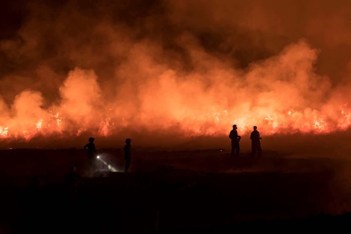 Firefighters tackle a blaze on moorland in northwest England on 21 April