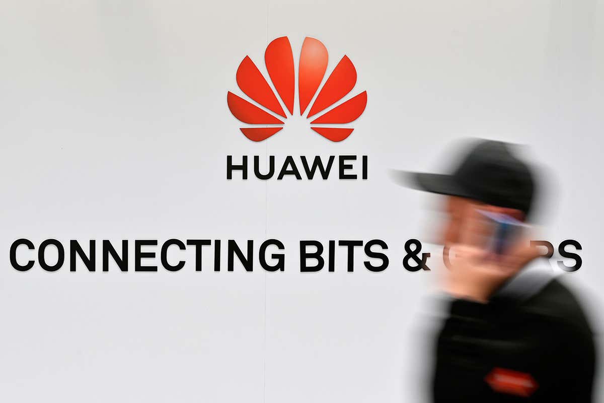 A picture of someone in front of a Huawei sign