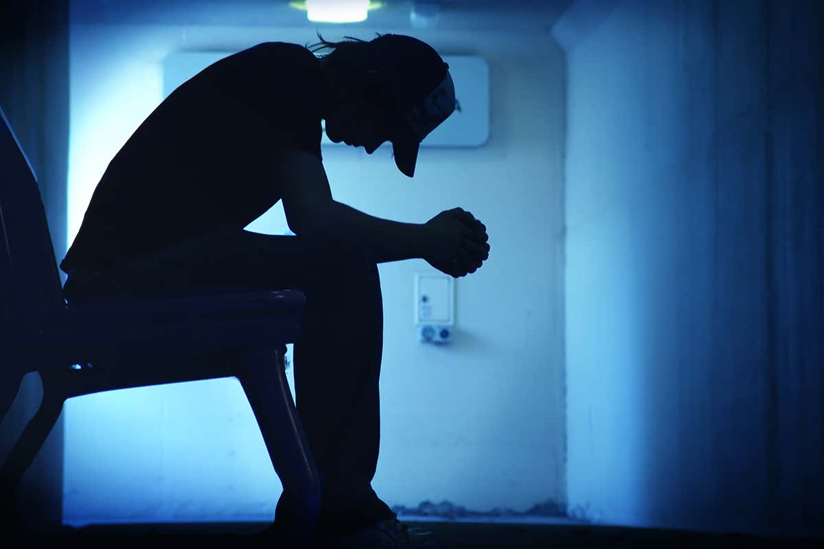 A person sitting in the shadows