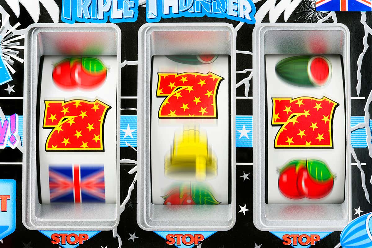 Fruit machine bars spinning to line of 7s showing probability