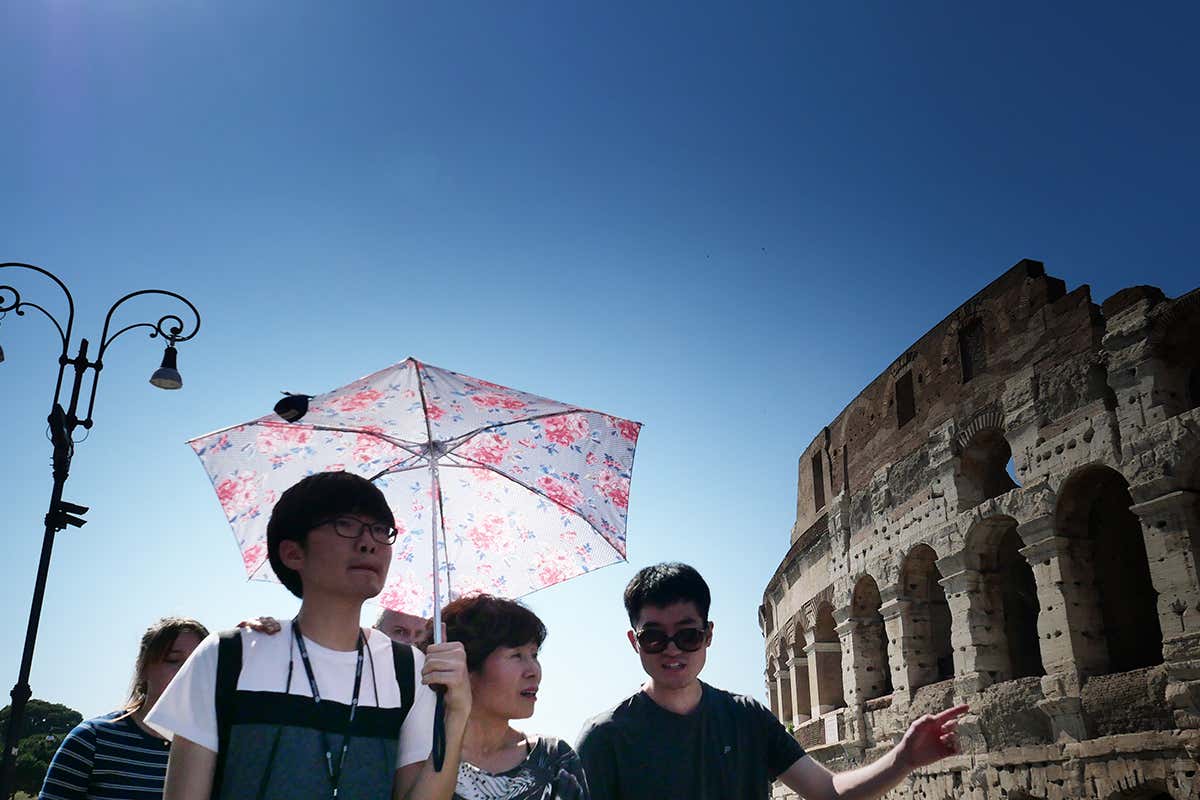 Person holding an umbrella in the sun