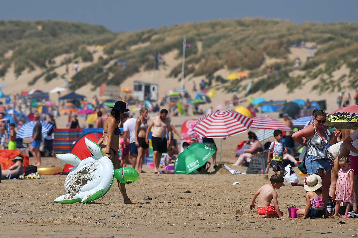 People on the beach in Camber Sands, England