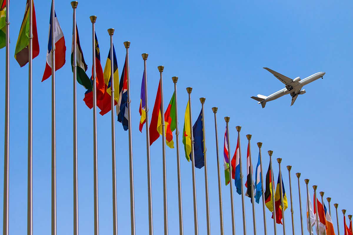 Aeroplane flying over a series of flags