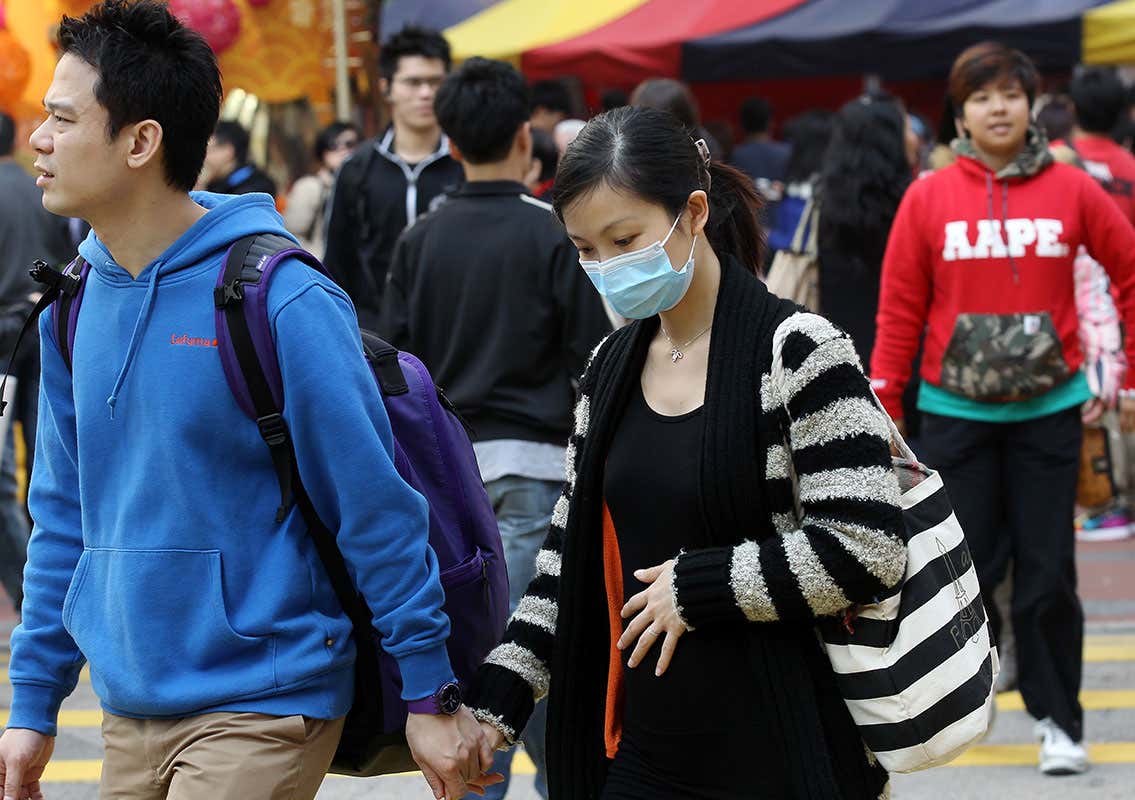A woman wearing a mask on a street in Causeway Bay as the roadside air monitoring station recorded an air pollution index of 141 at 12pm.