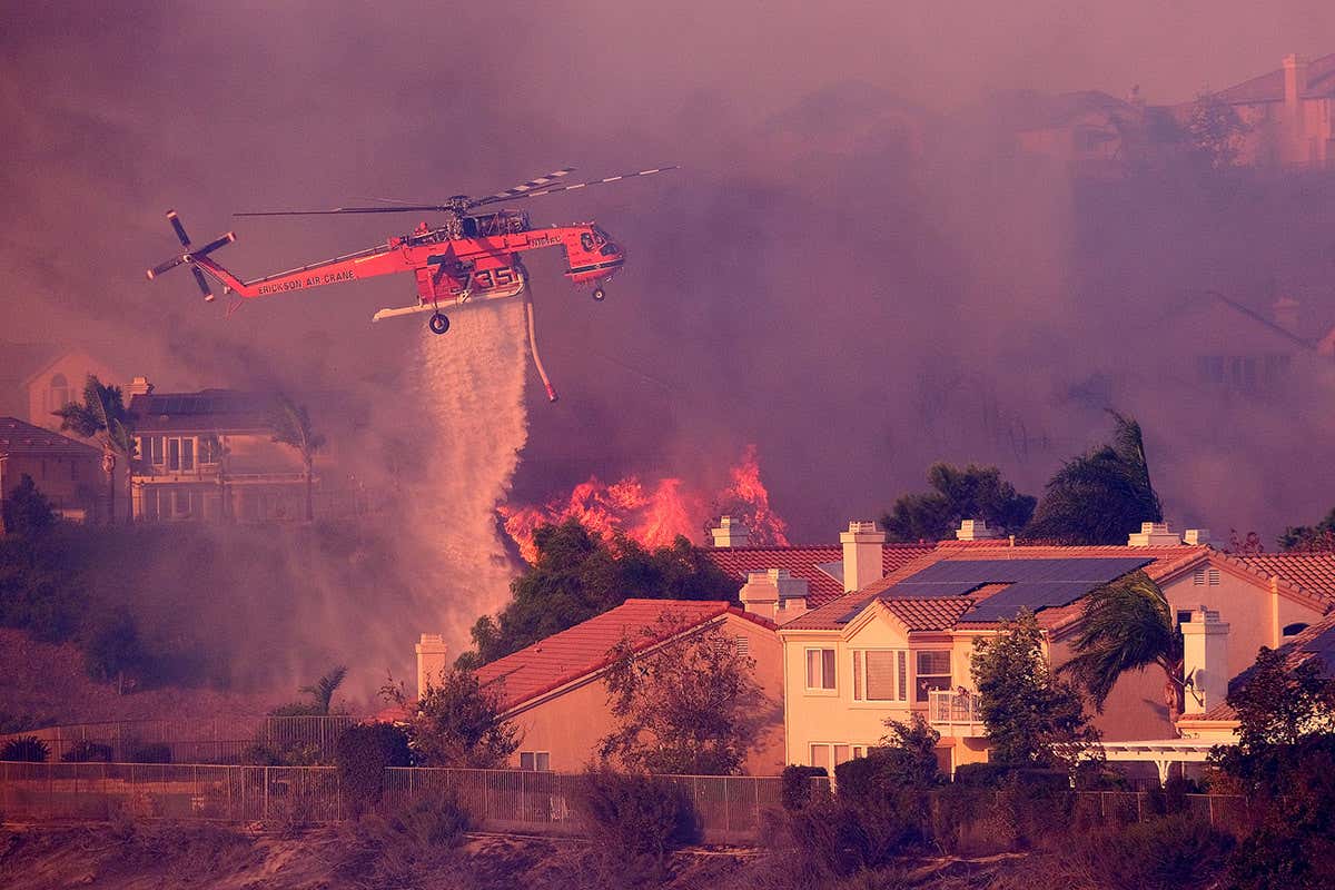 Helicopter dropping water on a house fire
