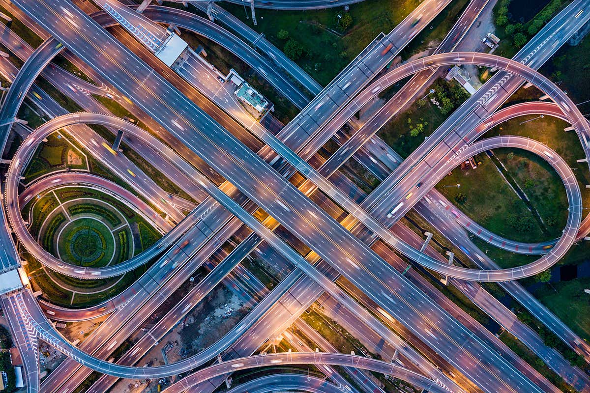 Top view of Highway road junctions at night. The Intersecting freeway road overpass the eastern outer ring road of Bangkok, Thailand.