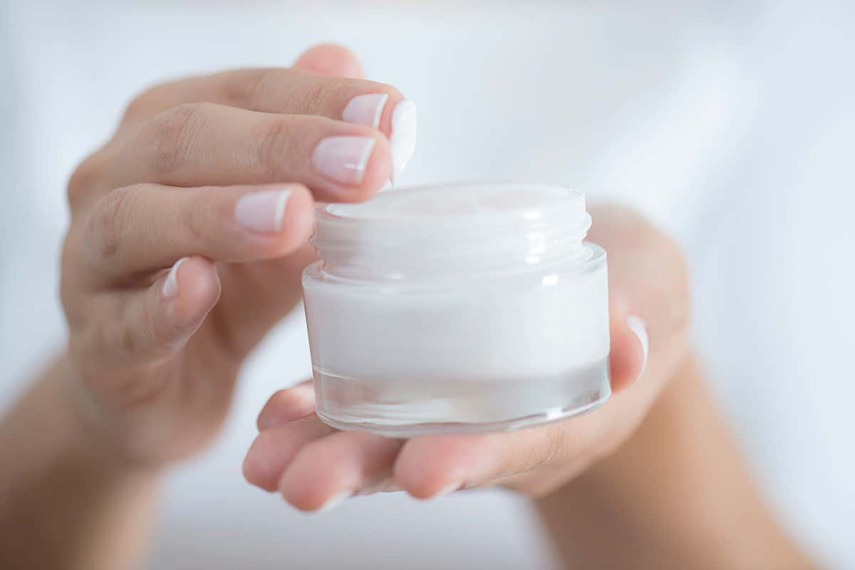woman holding skin cream
