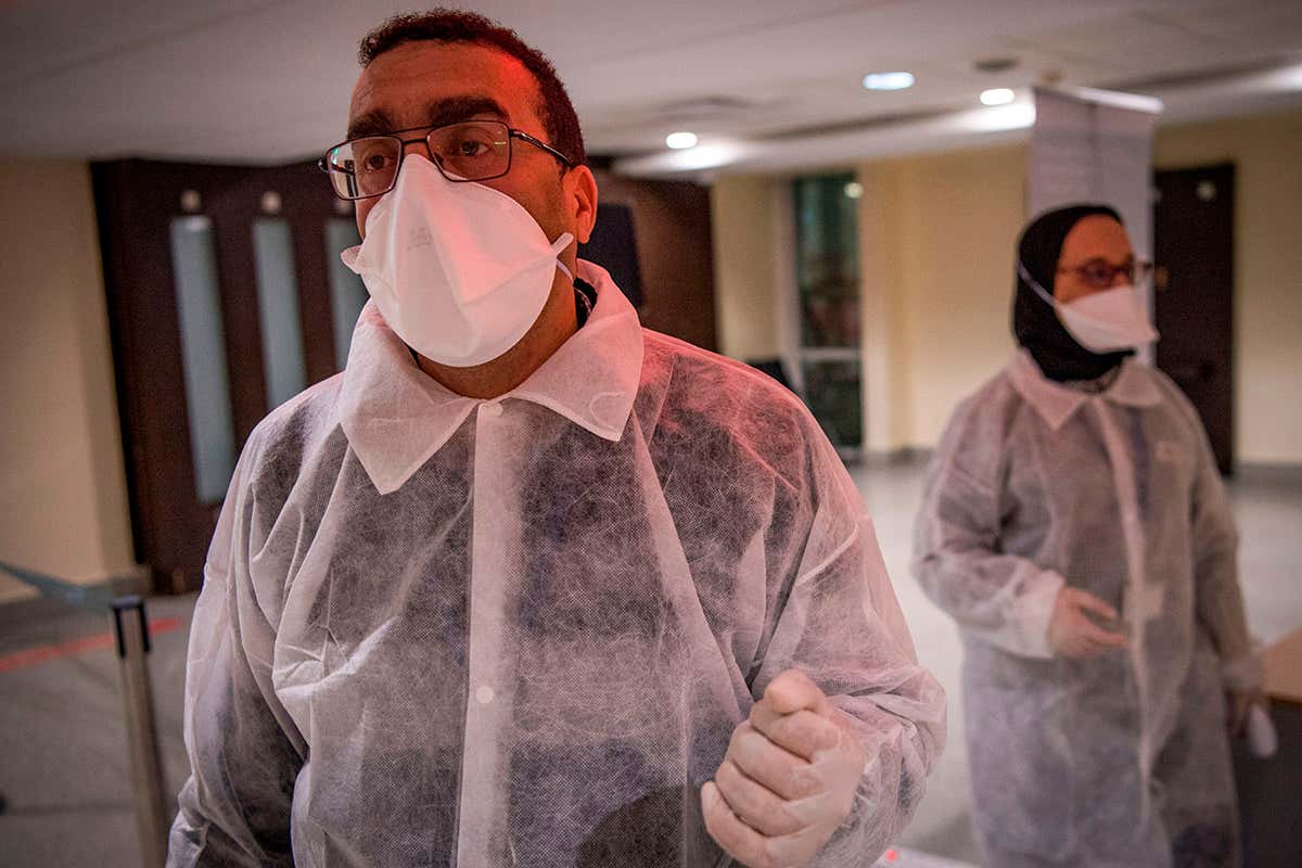 Moroccan health workers scan passengers arriving from Italy