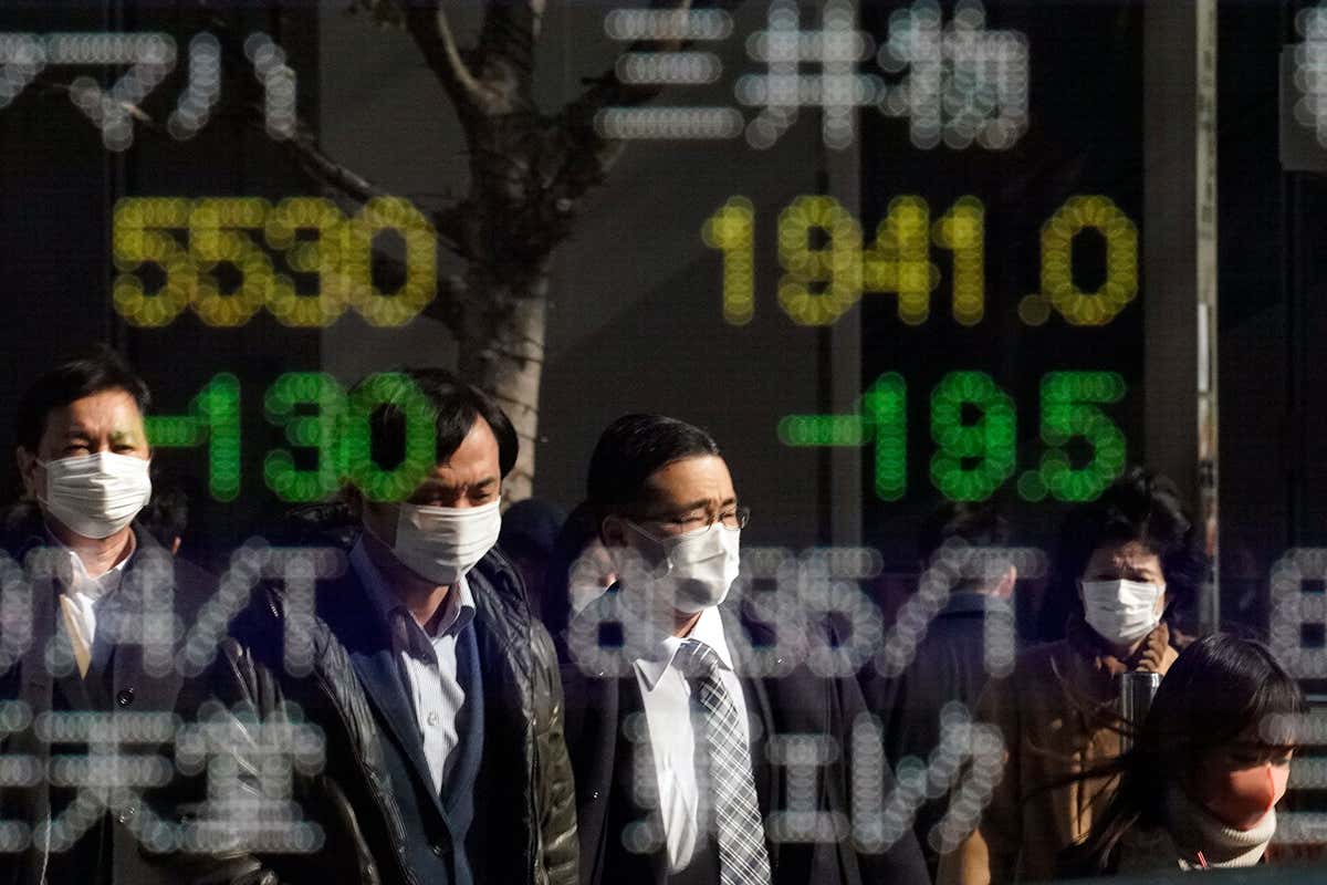men in front of stock ticker