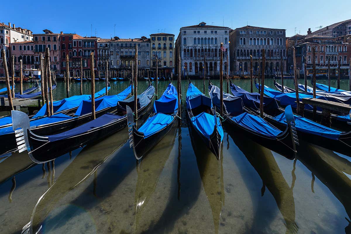 TOPSHOT - A view shows clear waters by gondolas in Venice's Grand Canal on March 18, 2020 as a result of the stoppage of motorboat traffic, following the country's lockdown within the new coronavirus crisis. (Photo by ANDREA PATTARO / AFP) (Photo by ANDREA PATTARO/AFP via Getty Images)